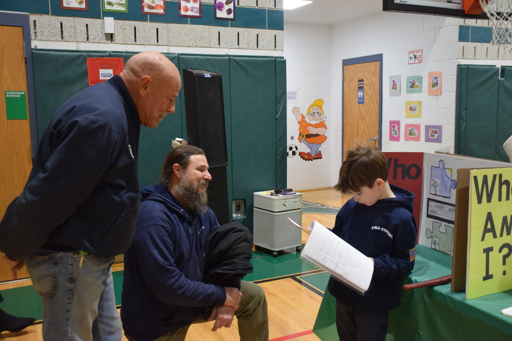 A Bayville Primary second grader explains his project to guests.