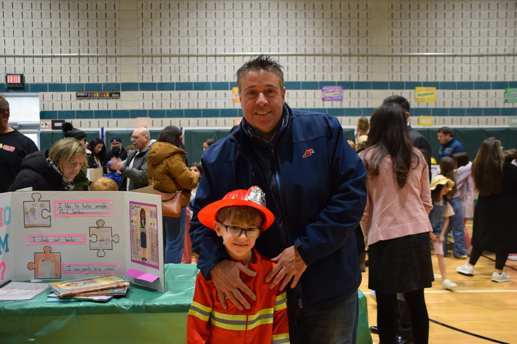 A Bayville Primary second grader shows his guest his display covering the firefighting profession.
