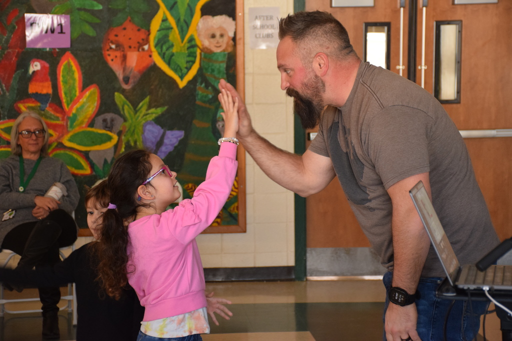 A student at Ann MacArthur Primary high fives Jared Campbell.