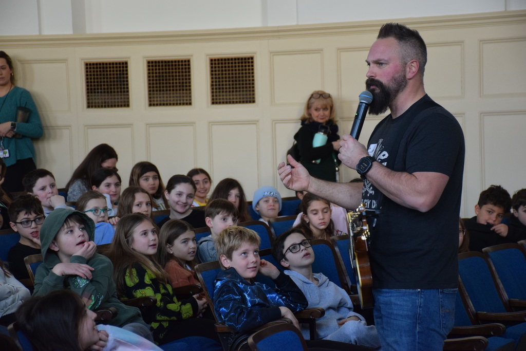 Bayville Intermediate students listen to Jared Campbell's advice on how to spread positivity.