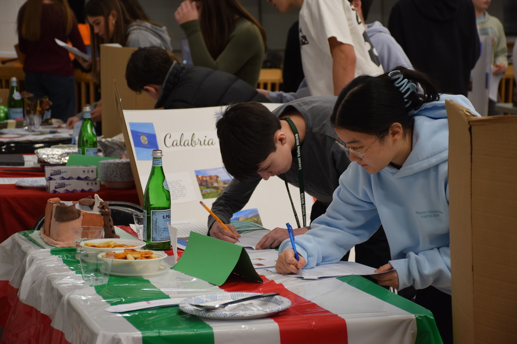 Middle school students visit another table to learn more about another region of Italy.