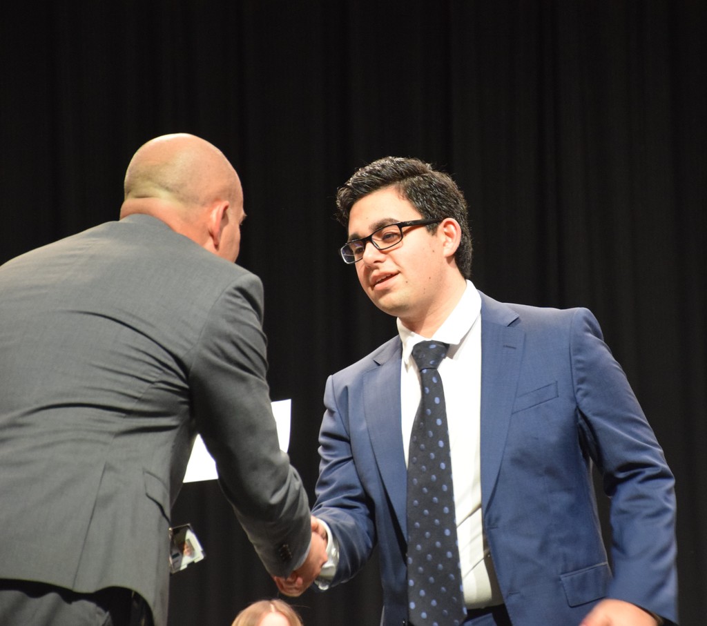 A new NHS inductee accepts his diploma.