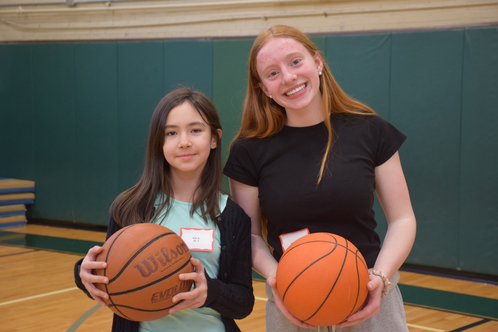 An elementary school student plays basketball with a high school student on Unplugged Night 2026.