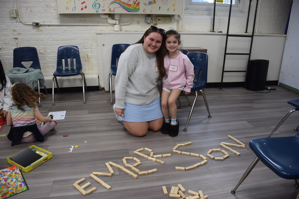 An elementary schooler and high school spell out their names with wood blocks on Unplugged Night 2026.