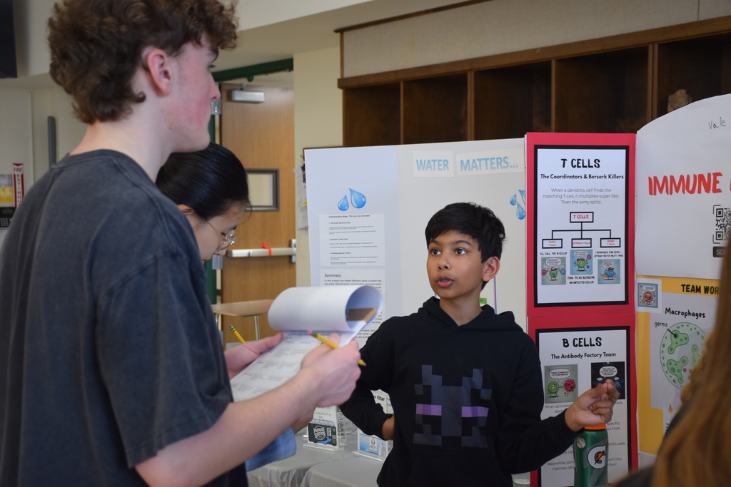 LVI's Vale Arcot explains his project to a high school judge.