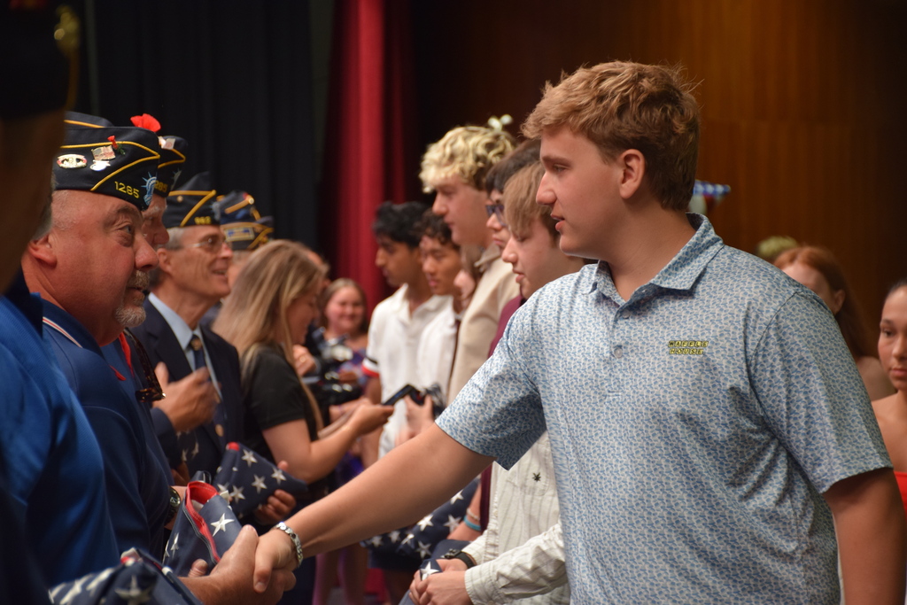 Locust Valley High School senior James Gallo spoke with a Bayville veteran about his service before receiving a tri-folded American flag.