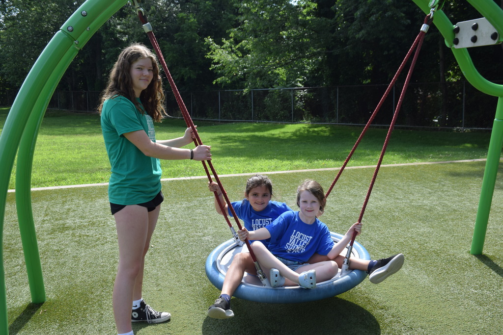 A summer recreation counselor with campers on a swing at Bayville Primary.