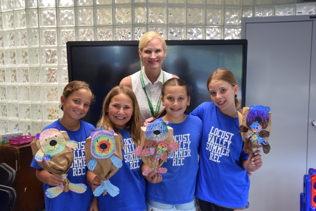 Summer recreation campers show Superintendent Dr. Turnow their crafts.