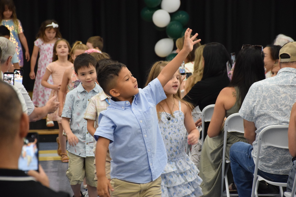 A BP kindergartner waves good bye to the school year.