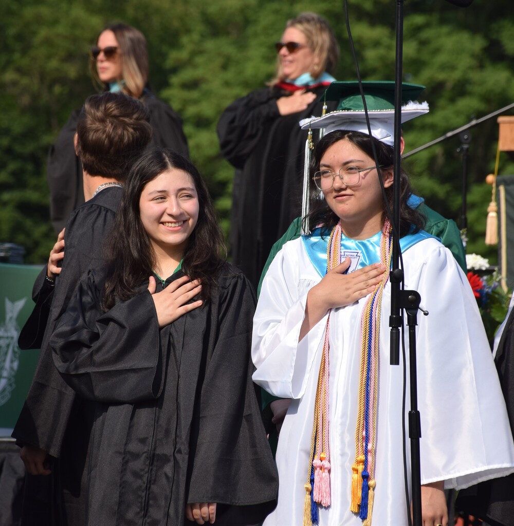 Alexandra Rivas and Grace Araoz at graduation, performing the national anthem.