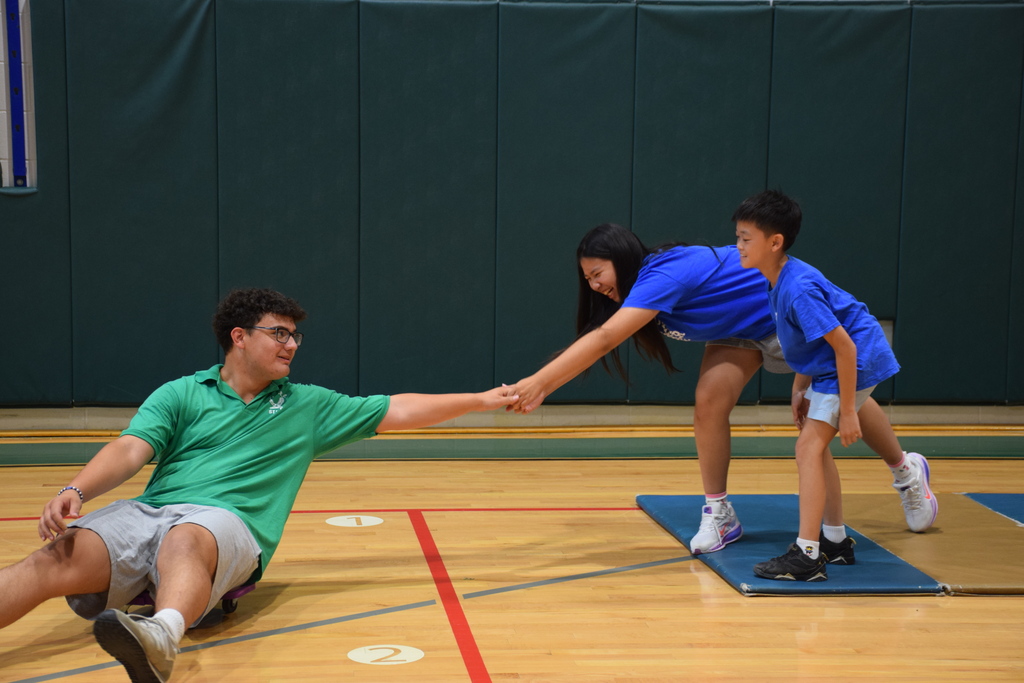 Summer Recreation campers help their counselor onto an island while playing a game of Long Island in July 2026.