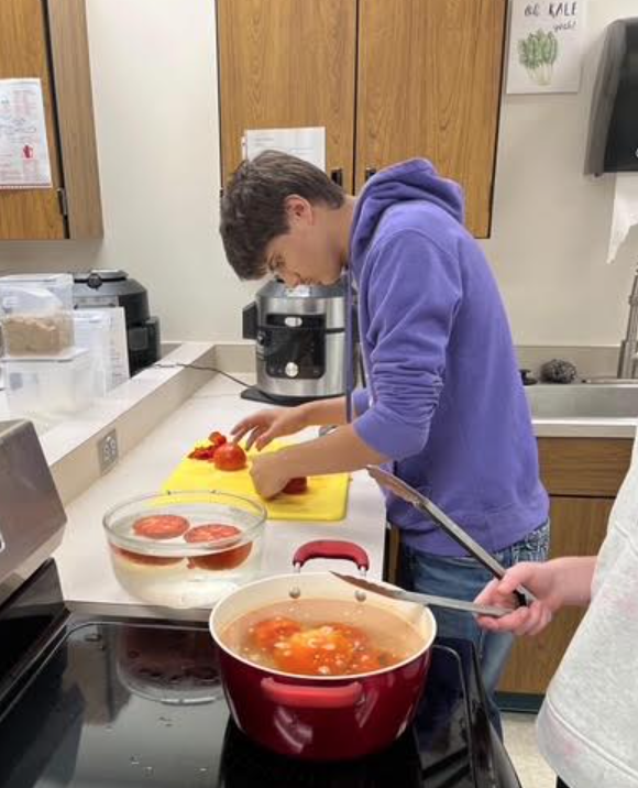 Student prepping student-grown vegetables that came from our Logan-Magnolia greenhouse.
