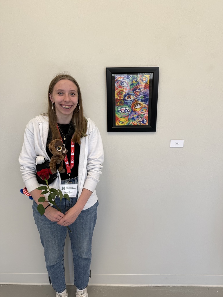Ellsie Meier standing by her artwork