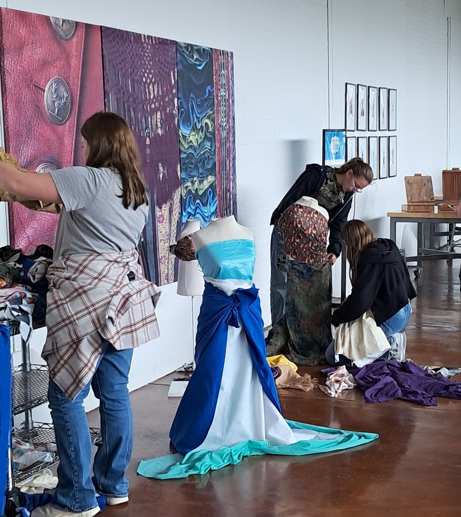 Students designing costumes with fabric.