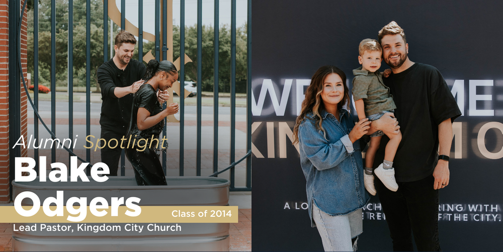 A brown haired man in wearing all black clothing smiles while baptizing a woman in a metal tub outside by a front gate. 