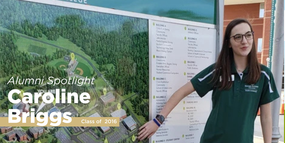 A black haired woman stands by a map of a college campus while giving a tour. 