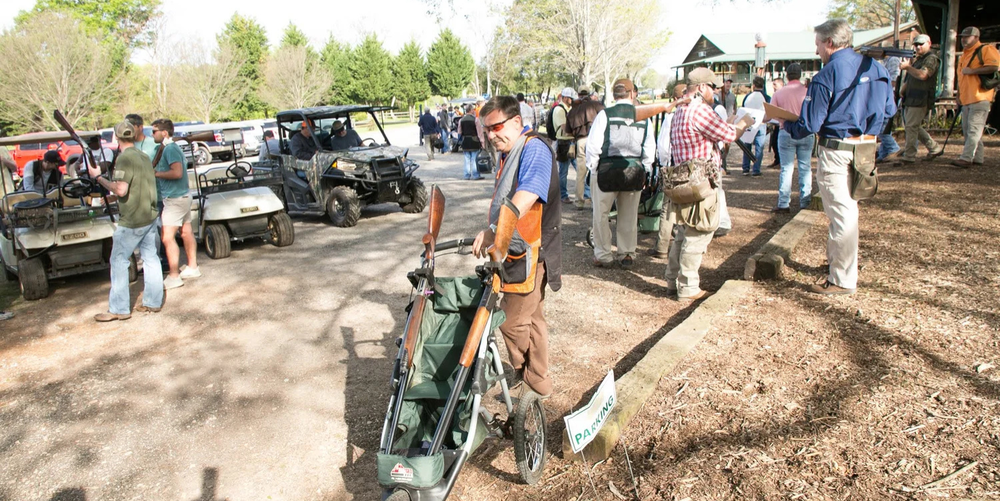 A large group of adults gather outside preparing to participate in a tournament for a fundraising event.