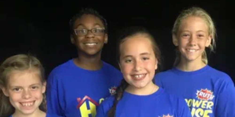 A group of elementary students pose for a photo smiling.