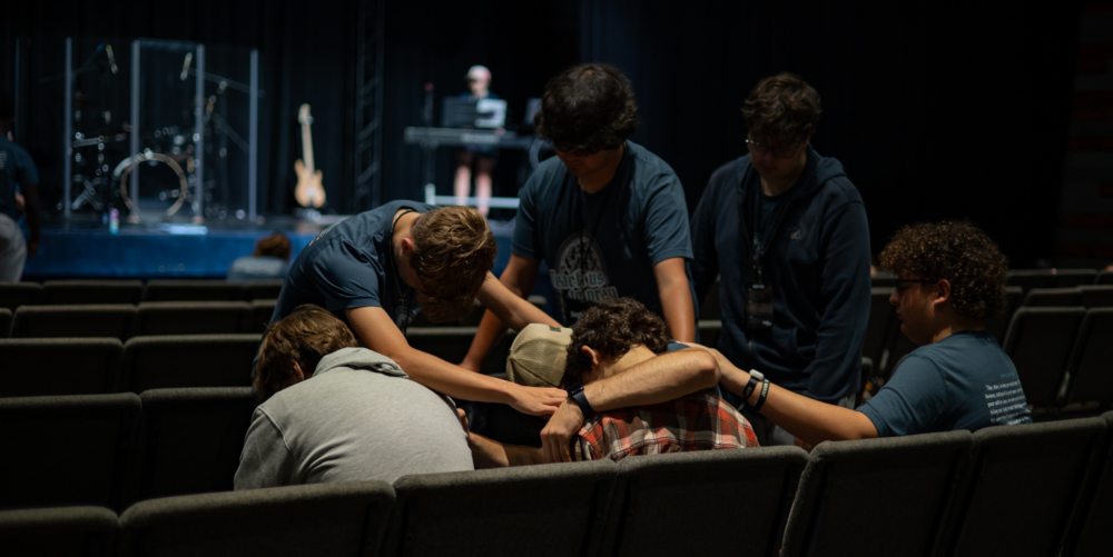 kids sitting in seats praying