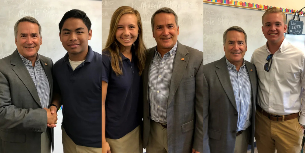 Three students take individual photos with a older politician who visited the campus.