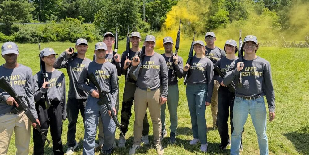 A group of boys wearing matching shirts and holding rifles