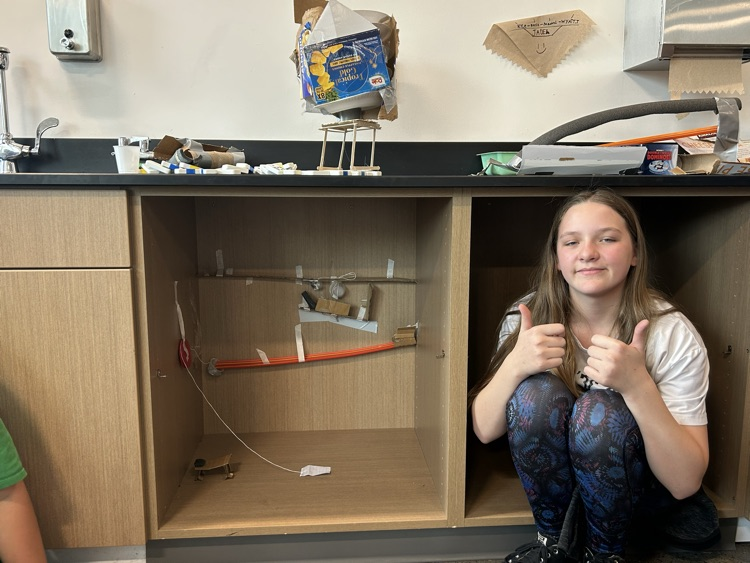 An eighth grader poses with her work.