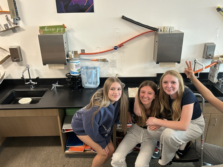 Three students pose with their Rube Goldberg machine.