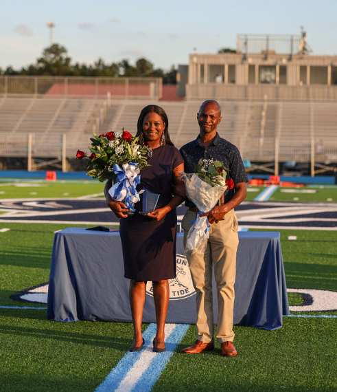 Congratulations Mrs. Powell. Seen here posing with her escort, Olakunle Awogboro, and holding both her Teacher of the Year and System Teacher of the Year awards. 