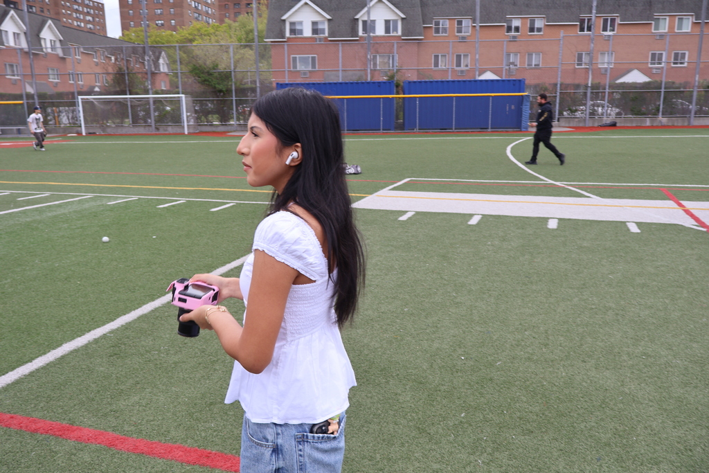 Yearbook student taking Lacrosse photos on the field. 