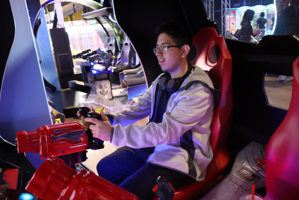 A senior plays an arcade game. 