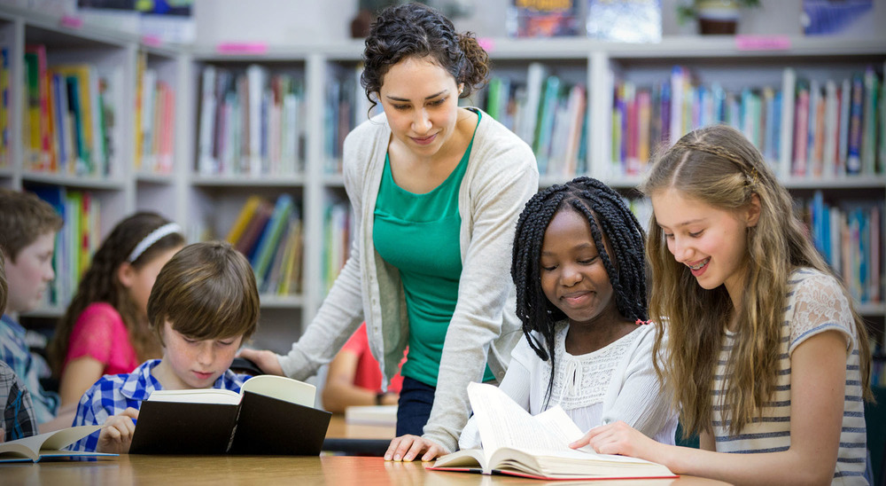 STOCK PHOTO - Teacher working with group of students