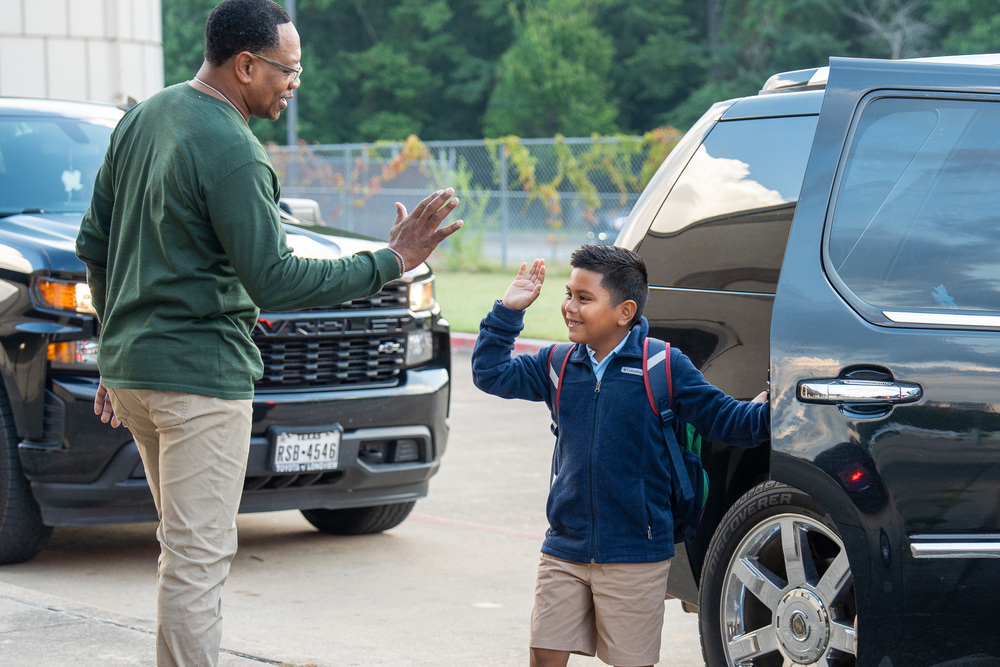 student high fiving staff 