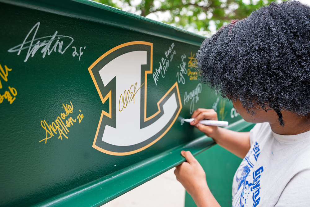 Student signing beam.