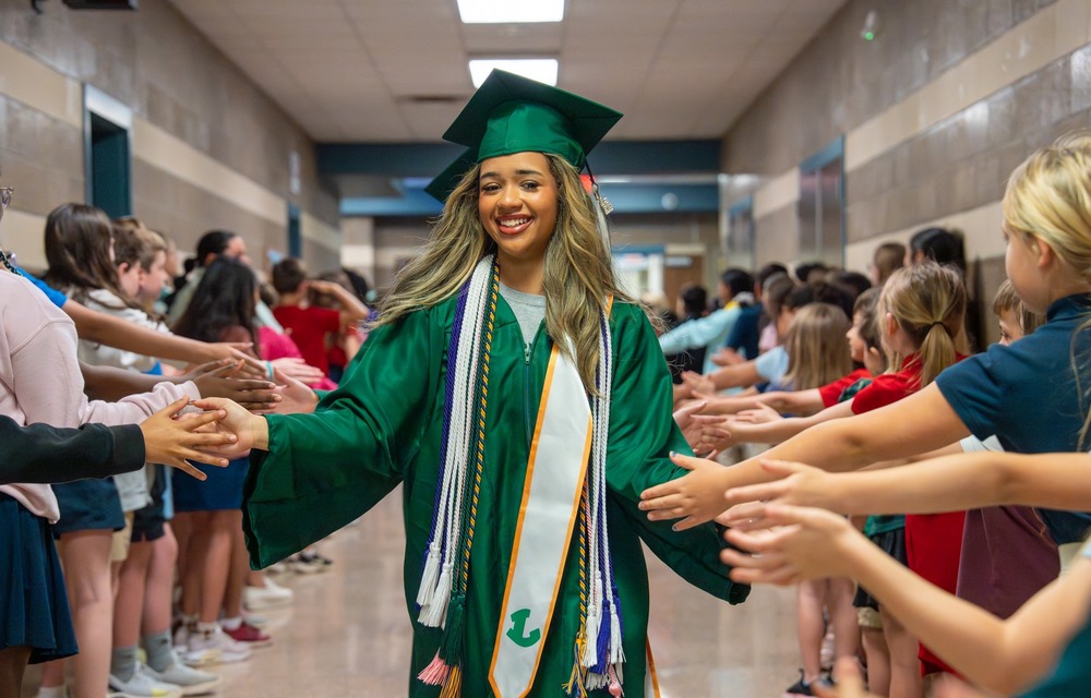 Senior giving high fives to elementary students.