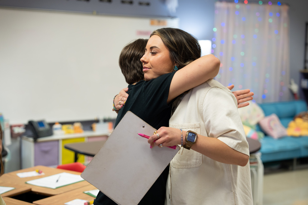 Ms. Thompson hugging a former student.