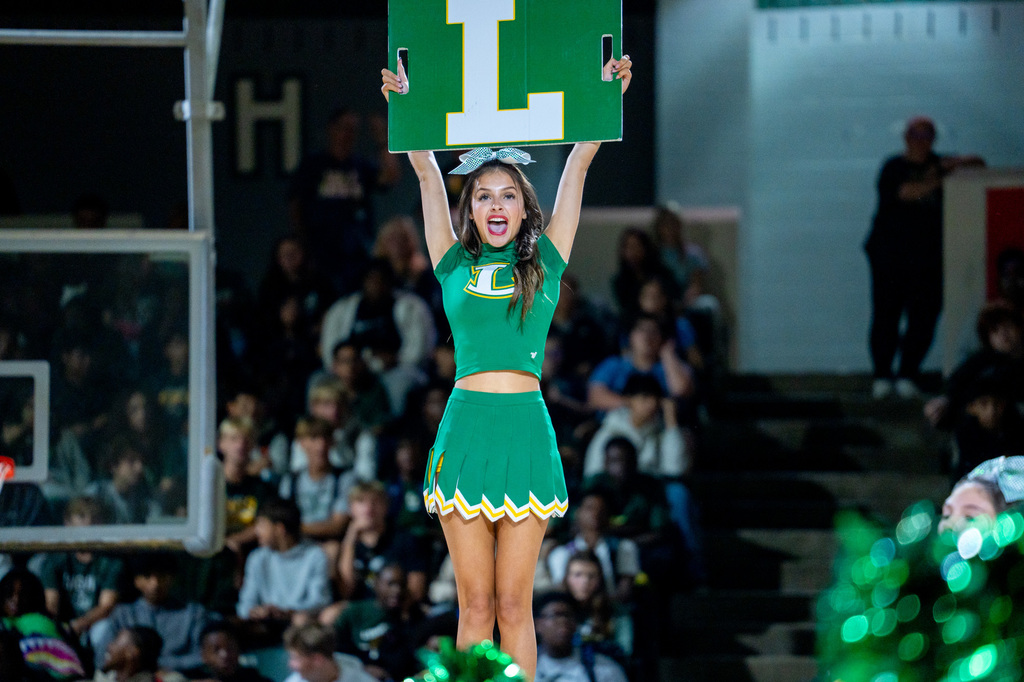 Cheerleader holding up the L sign in her stunt.