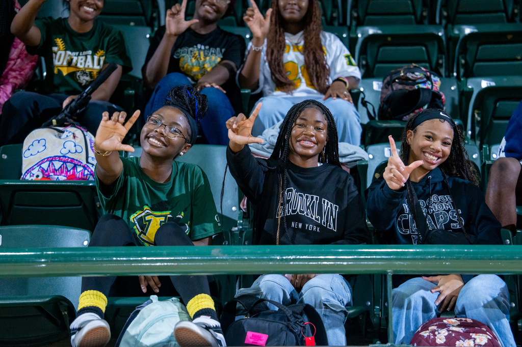 Students showing the rocking L hand sign in the stands.