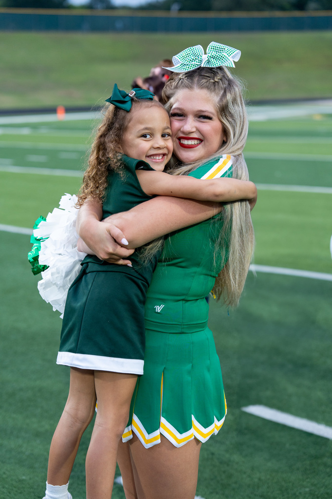 Longview cheerleader hugging a mini longview cheerleader.