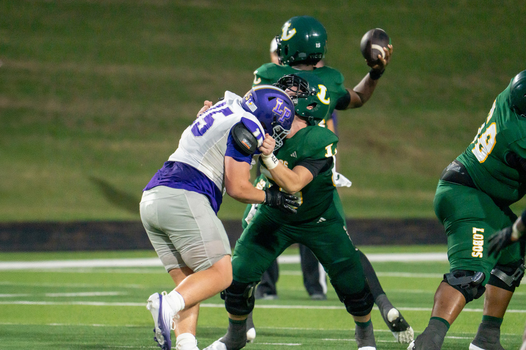 Longview football player blocking for the quarterback to throw the ball.
