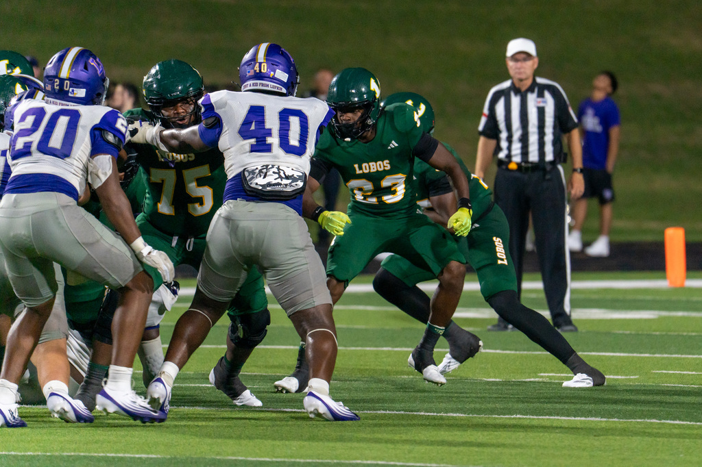 Longview football players pushing the Lufkin players on the line.