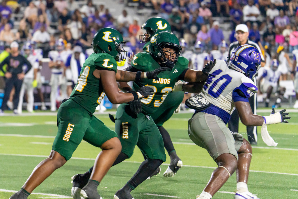 Two Longview football players blocking number 40 from Lufkin.