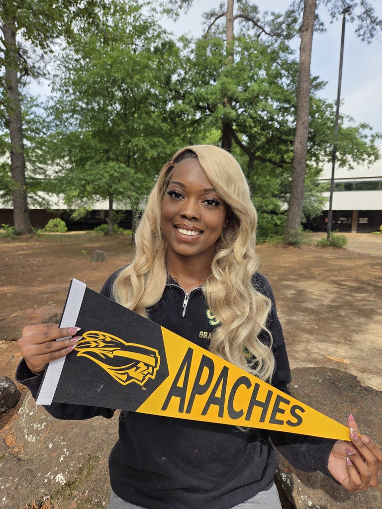 Zamya holding an TJC Apaches pennant to celebrate attending TJC for sonography.