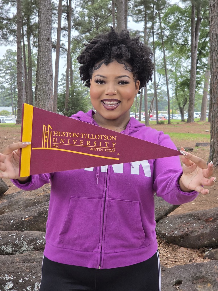 J'La holding out her Huston-Tillotson pennant and smiling big because she will be studying business administration.