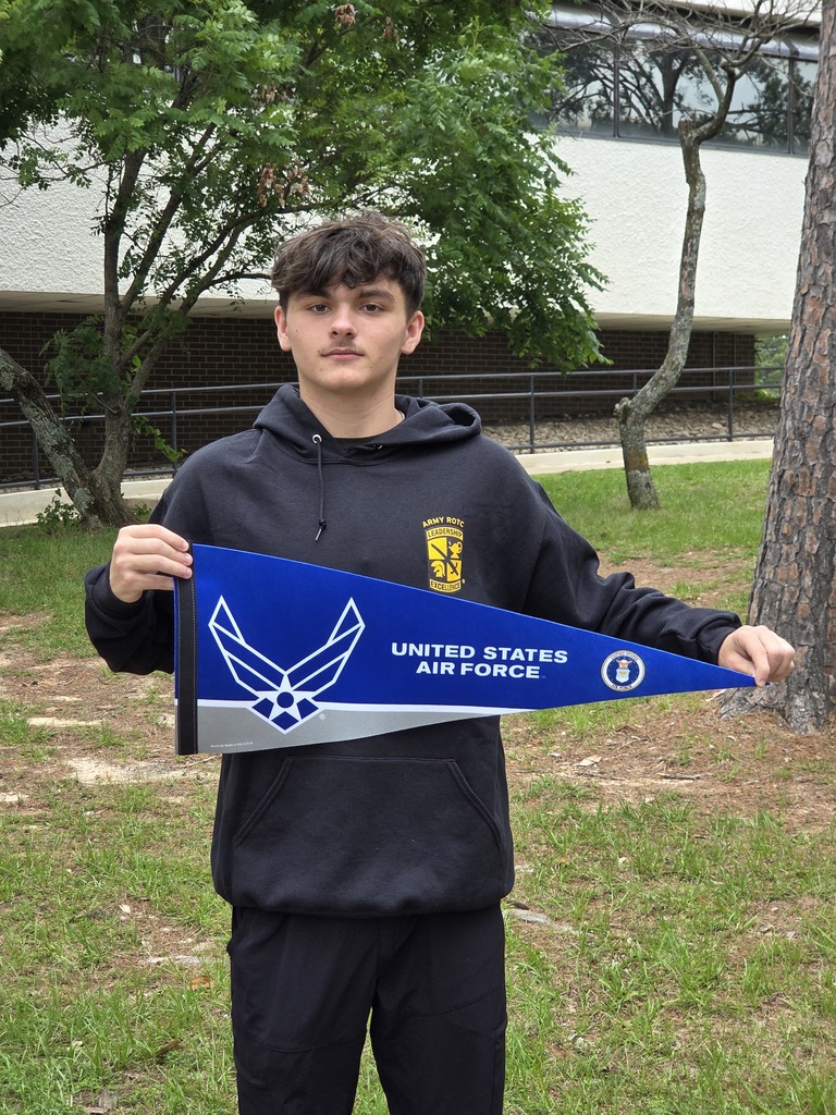 Triston wearing his JROTC hoodie and holding an Air Force pennant
