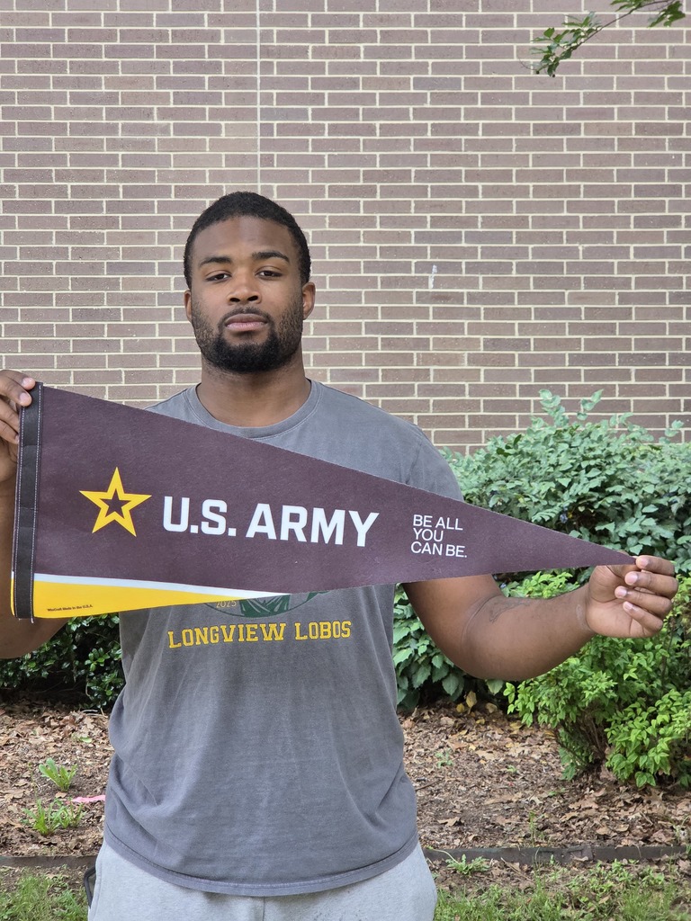 Darryl standing outside holding a US Army pennant