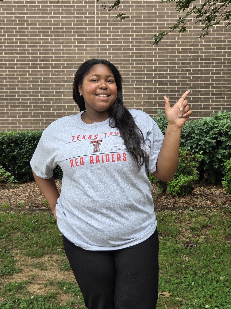 Samaya is wearing a Red Raider shirt giving the school hand sign