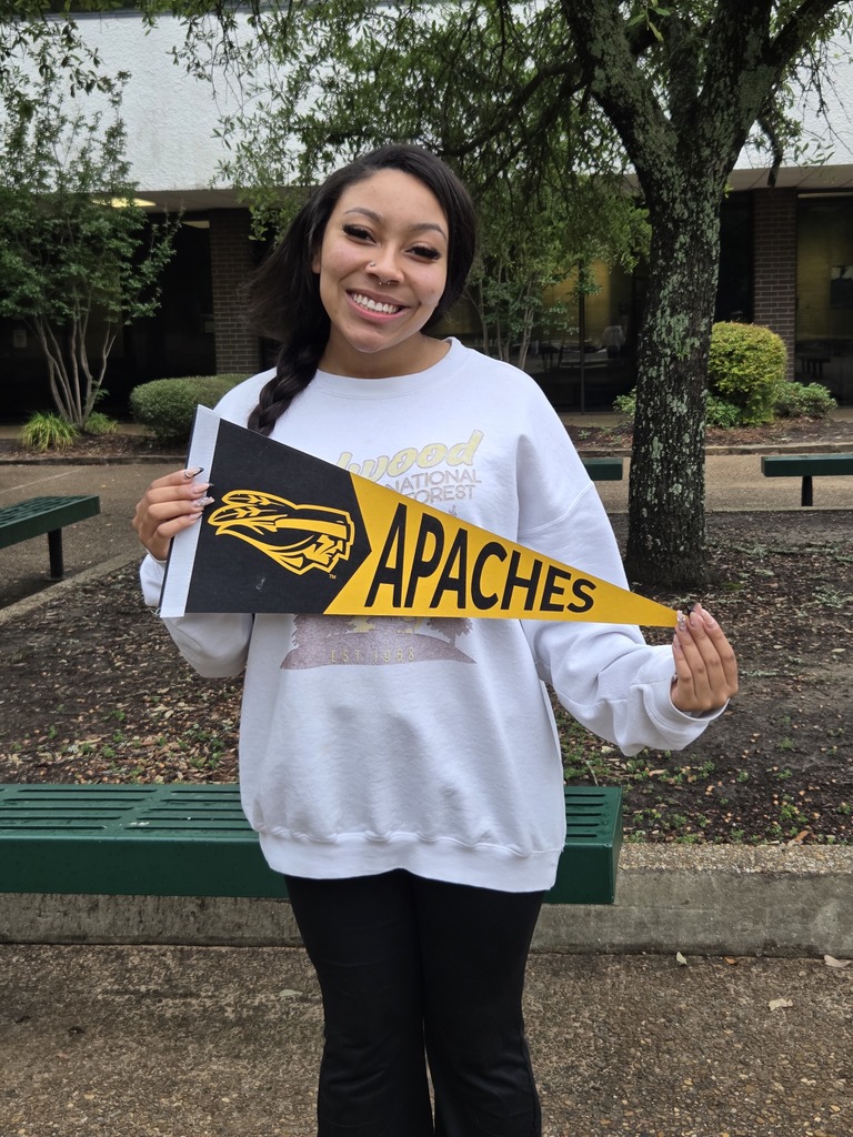 Mila is holding a Tyler Junior College pennant.