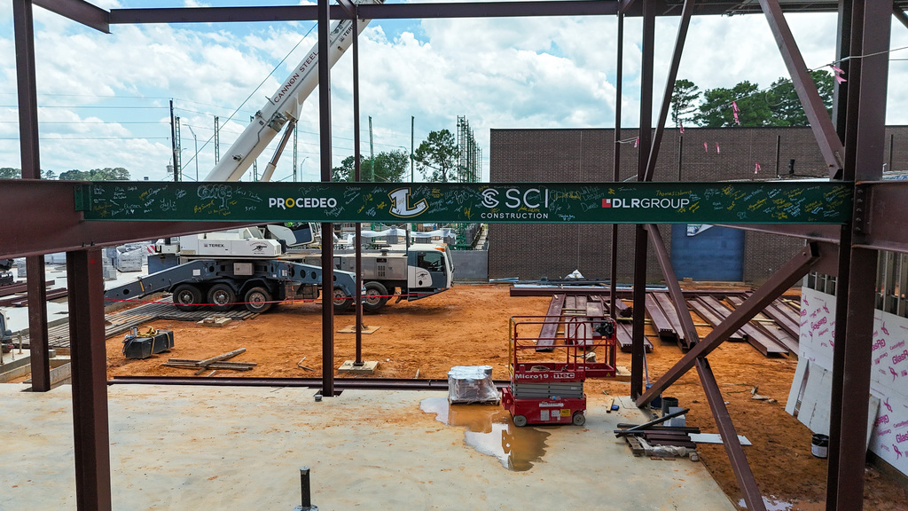 A green steel beam signed by members of Longview High School's 2026 Senior Class installed as part of the new Career and Technical Education Facility