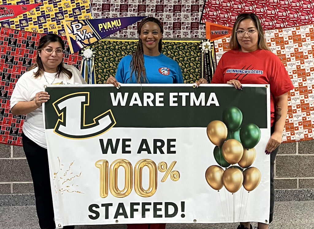 Ware ETMA staff poses with 100% staffed banner.