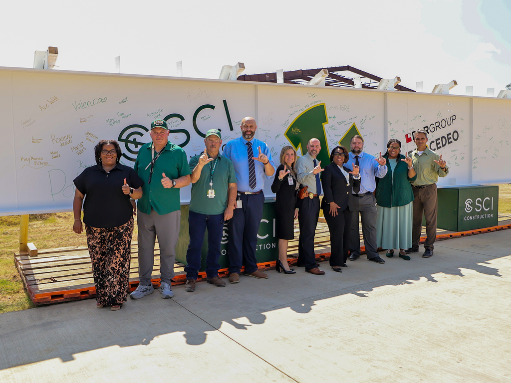 Longview ISD administrators standing in front of the beam